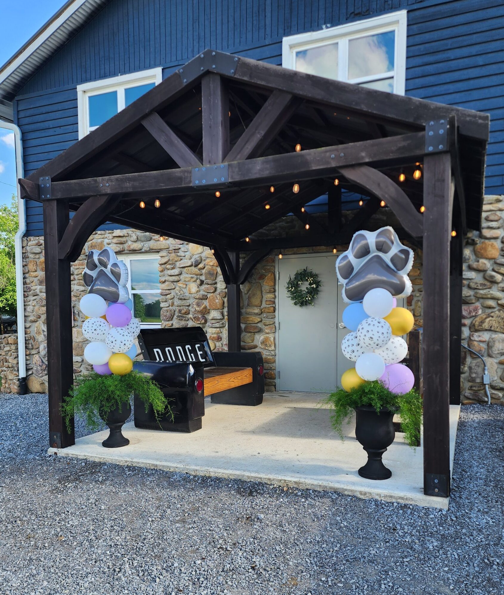 Front entry patio at Rock Spring Resort event center with balloon towers on potted plant bases set up for Dancing 4 Dogs event.