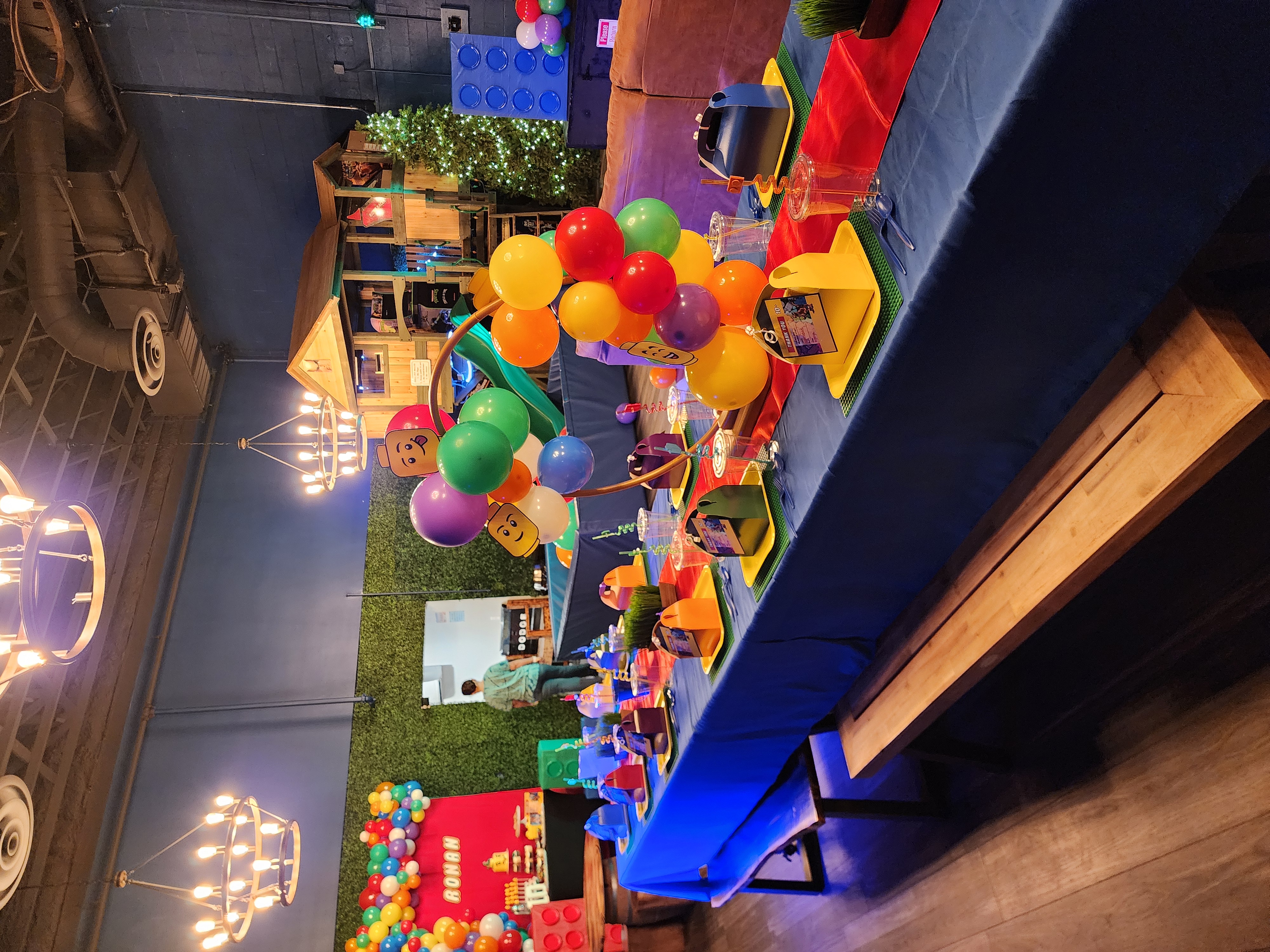 Lego-Themed birthday party table setup at Rock Spring Resort event center with balloon arch, treehouse, and custom decorations.