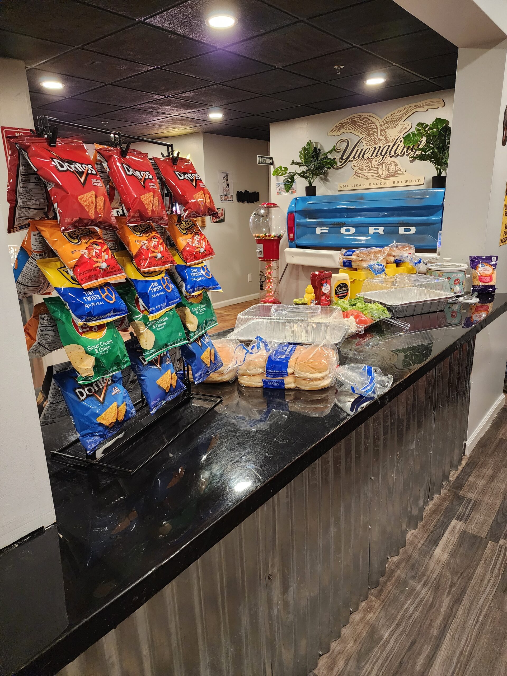 Food spread on kitchen counter at Rock Spring Resort with corrugated metal cabinet siding and tailgate bar visible in the background