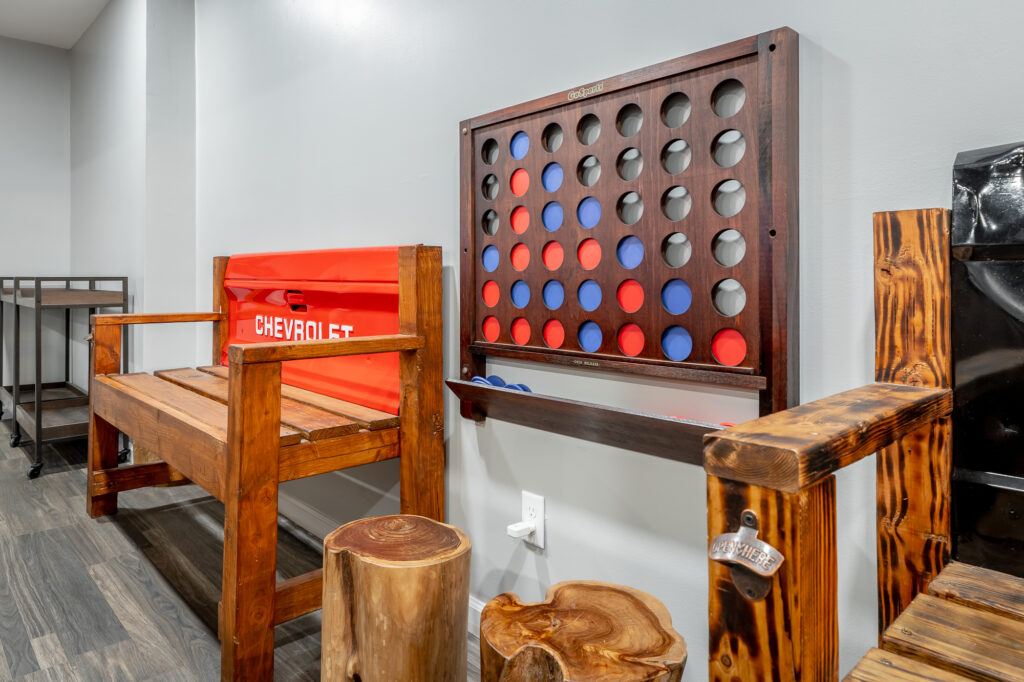 Custom truck-themed bench and wall-mounted giant Connect 4 game in hallway